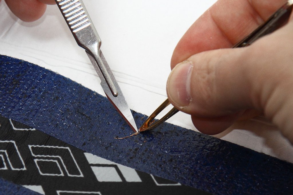 Use tweezers and a blade to remove coarse impurities from the adhesive.