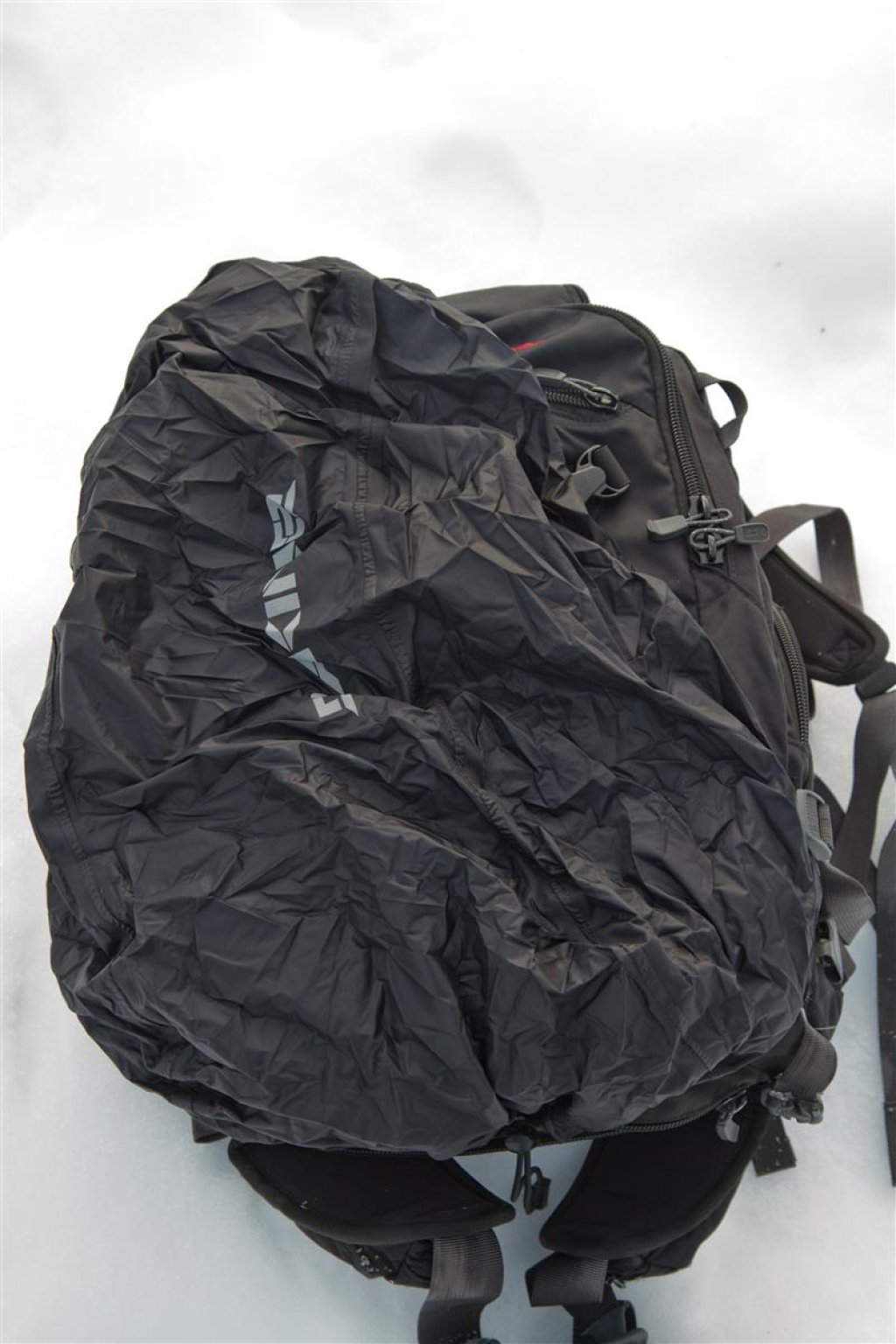 The integrated rain cover is stowed in a compartment at the bottom of the backpack and is detachable