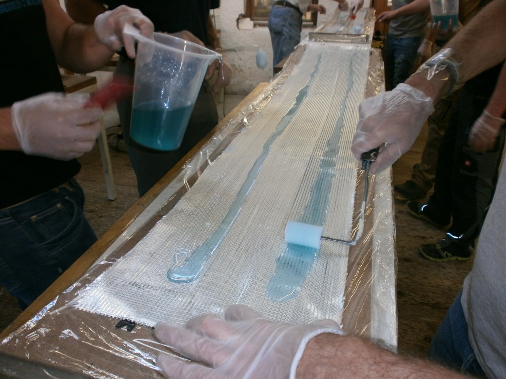 The resin-hardener mixture is distributed on the skis using small rollers