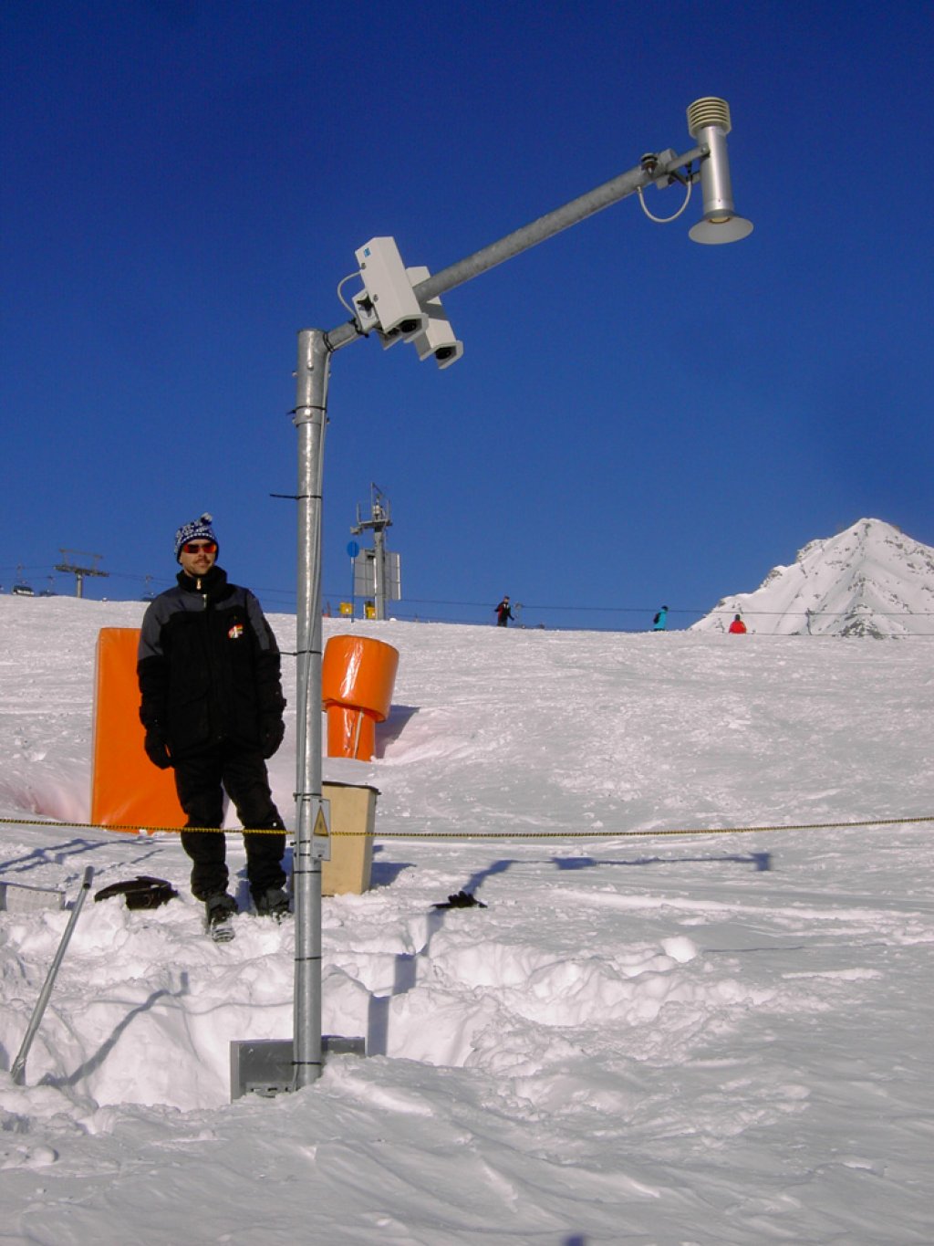 Laser/ultrasonic snow depth measurement. The sensors hang on the pole and measure the distance to the snow surface.